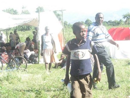 vista del los sobrevivientes viviendo en un campo cerca del orfanato.