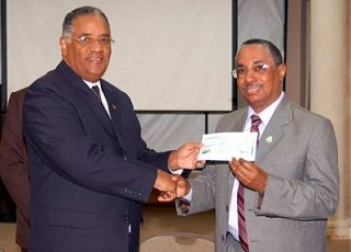 Foto: Obispo Marrero recibiendo el cheque del representante del gobierno